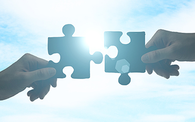 Hands holding puzzle pieces that fit together